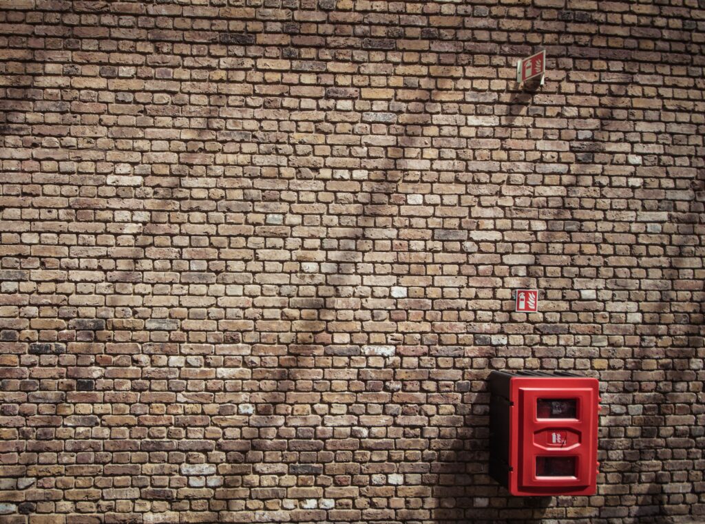 Fire extinguisher case mounted on brick wall.
