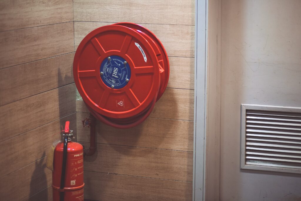 Fire extinguisher and hose in the corner of a commercial stairwell. 