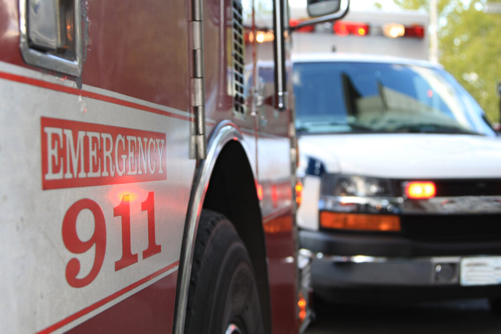 Close-up of emergency vehicles dispatched to a fire. Side of truck says "Emergency 911"